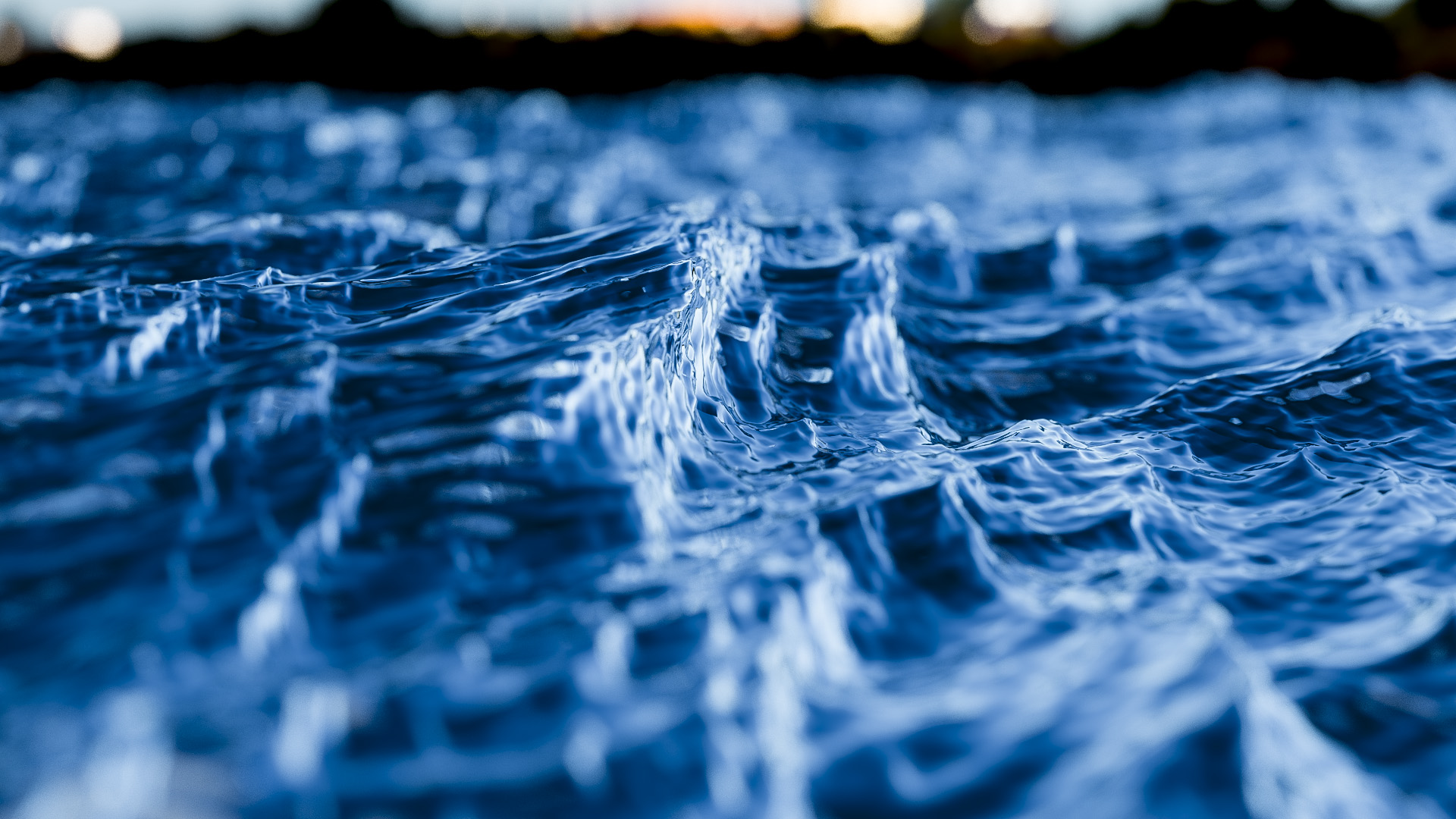 Figure 3: Another view of the vector displaced ocean surface from Figure 1. The ocean surface has a dielectric refractive material complete with colored attenuated transmission. A shallow depth of field is used to lend added realism.